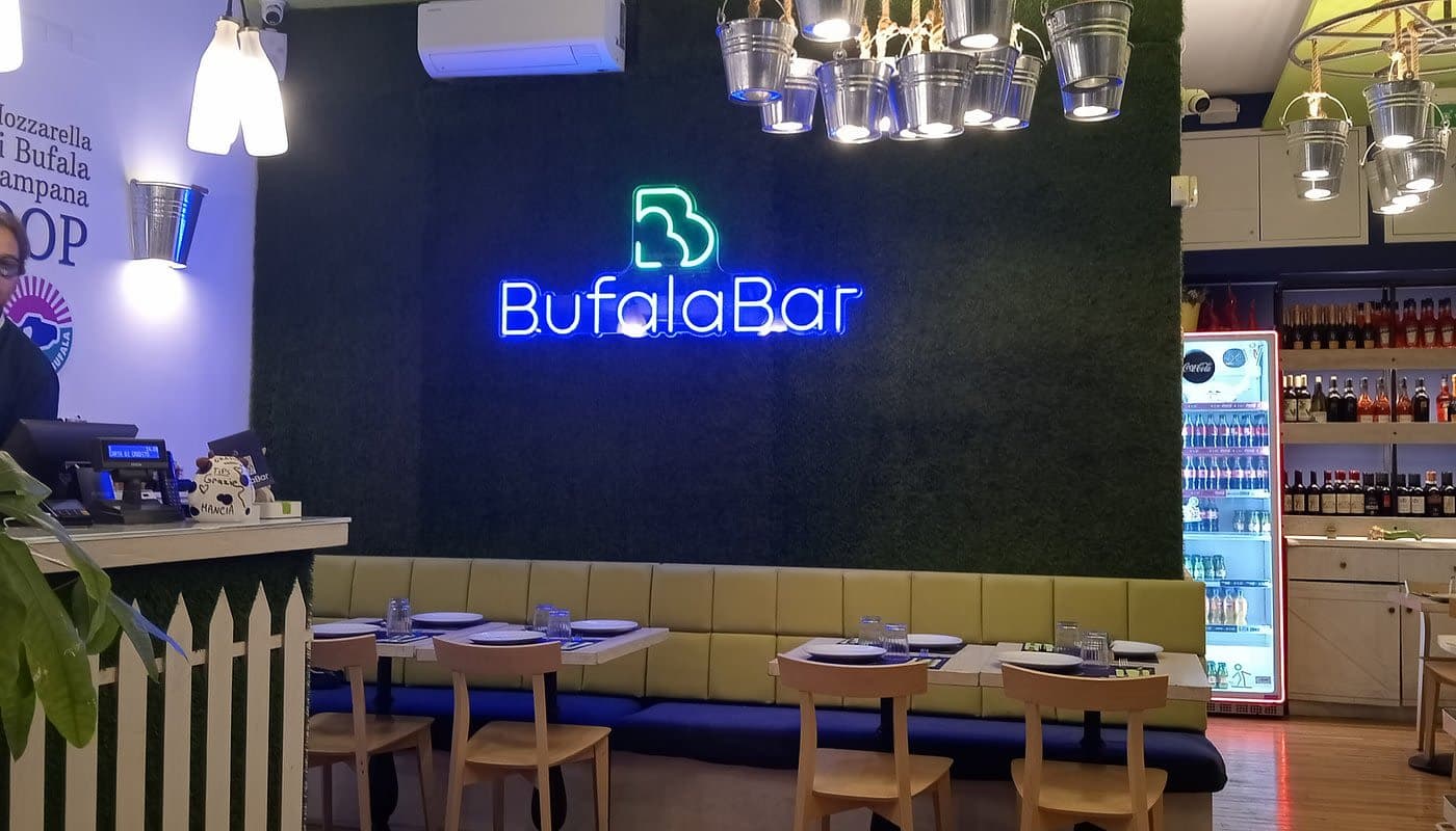 Bufala Bar interior with illuminated BufalaBar neon sign in Caserta